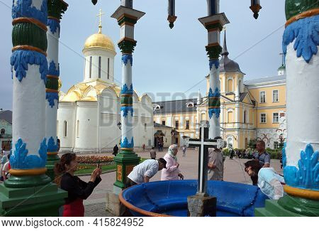 Sergiyev Posad, Russia - June 26, 2019: Chinese tourists taking photo at Holy water spring under colorful canopy at Trinity Lavra of St. Sergius. Russian christian architecture