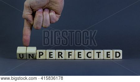 Perfected Or Unperfected Symbol. Businessman Turns Wooden Cubes And Changes The Word Unperfected To 