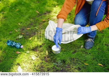 Volunteer Picking Up The Plastic Garbage And Putting It In Biodegradable Trash-bag On Outdoors. Ecol