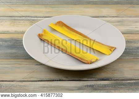 Two Banana Toffee Taffy Candy Strips  On White Snack Plate