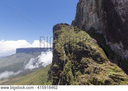 Sheer Cliffs Of Mount Roraima - Landscape With Blue Sky And Clouds Background. View On The Gran Saba