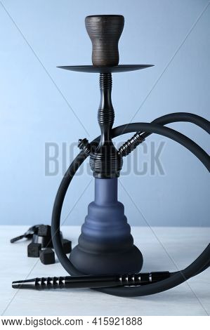 Traditional Hookah On White Table Against Light Blue Background