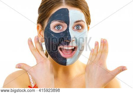 Woman With Clay Carbo Black Mask On Half Face And White Mud On Second Half. Girl Taking Care Of Oily
