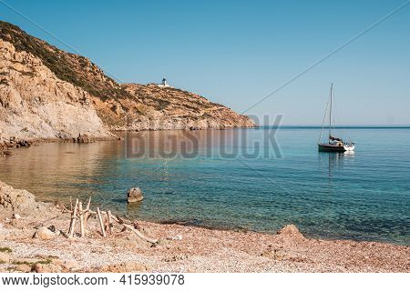 A Sailing Yacht Is Moored In A Bay On The Translucent Mediterranean Sea On The Coast Of La Revellata