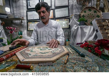 Shiraz, Iran - 04.10.2019: Iranian Khatam Master Woking Behind The Desk In His Shop In Shiraz, Iran.