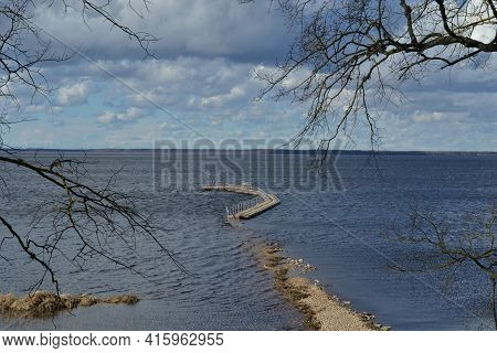 Landscape With A Lake, Which In The Spring Floods Flooded A Wooden Footpath Immersed In River Water.