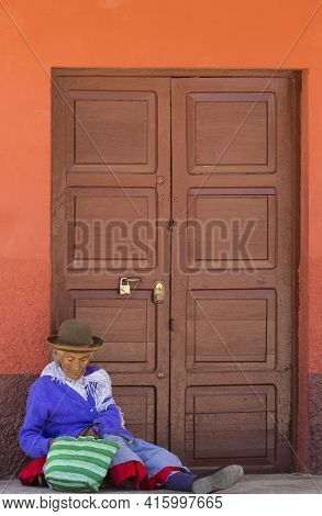 Tupiza, December 28: Old Bolivian Women Sitting On The Floor In The Street In Front Of Wooden Doors 