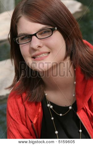 Headshot de menina em vermelho com fundo rochoso de fluxo