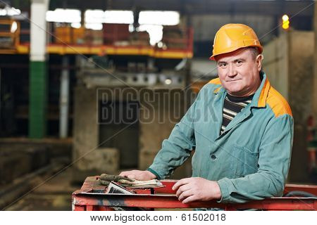 portrait of positive adult industrial worker at factory workshop