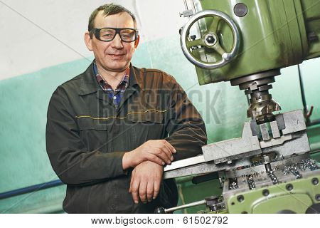 milling machine operator working in factory workshop
