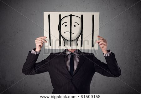 Businessman holding a paper with a prisoner in jail behind the bars on it in front of his head