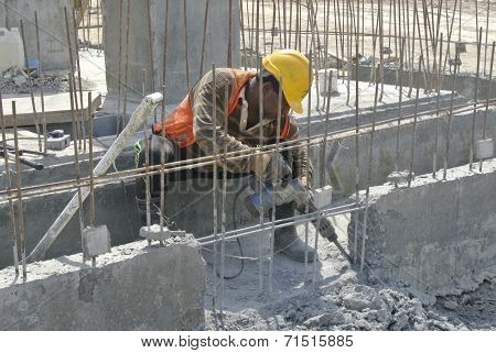 A construction workers hacking concrete beam
