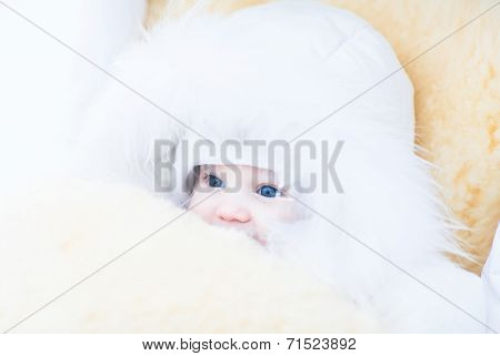 Baby Girl In A White Fur Jacket Sitting In A Stroller With A Warm Sheepskin Foot Muff