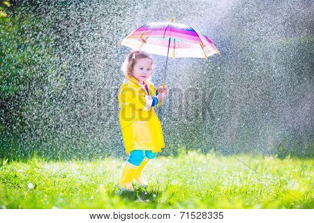 Funny Toddler With Umbrella Playing In The Rain