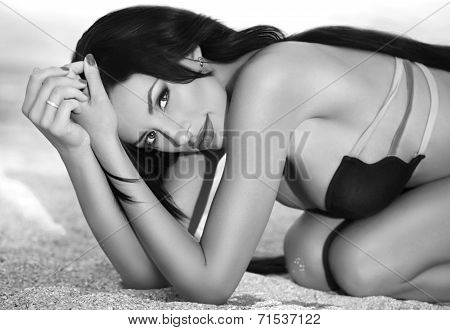 Beautiful nude brunette posing on the beach