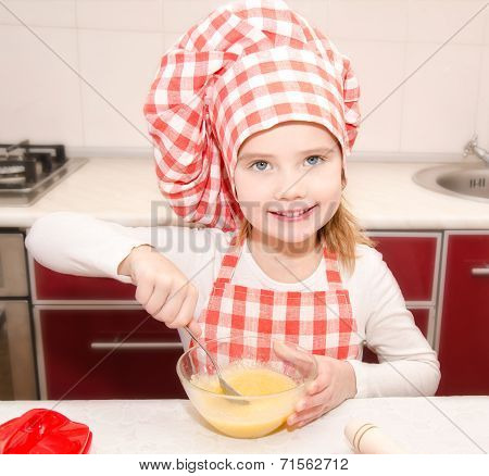 Smiling Little Girl With Chef Hat Stirrring Cookie Dough