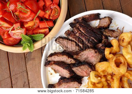 Flank Steak With Fries Onion Rings And Salad