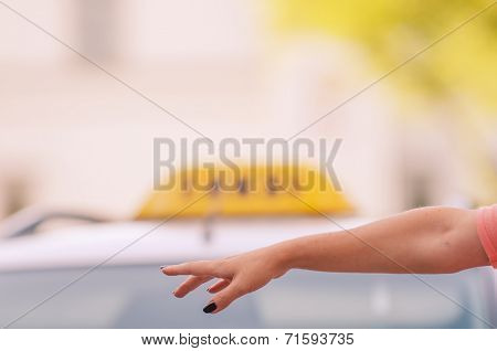 woman raising her arm to call a taxi