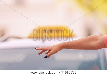 woman raising her arm to call a taxi
