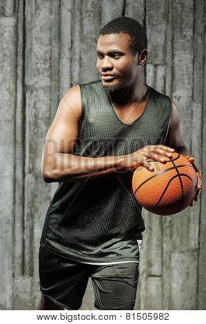 Afro-american male basketball player holding ball