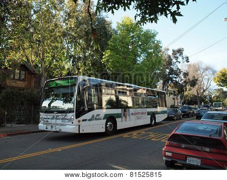 Ac Transit Bus With Ads Displayed On Side Driving Down The Street