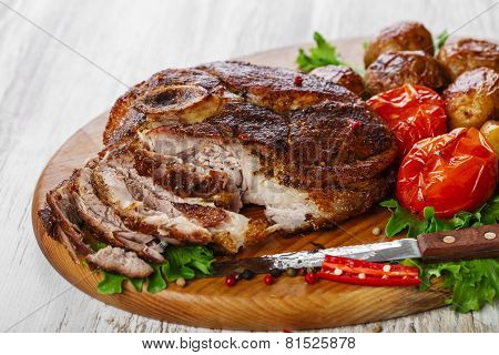 roasted pork shoulder on the bone with potatoes