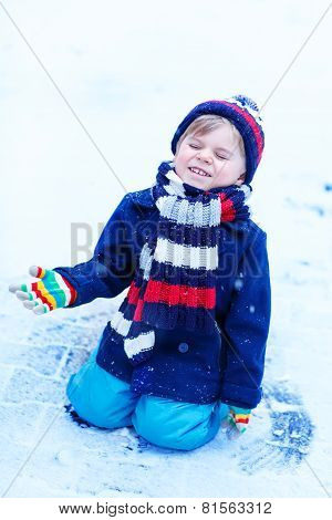 Cute Little Funny Boy In Colorful Winter Clothes Having Fun With