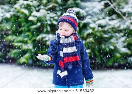Cute Little Funny Boy In Colorful Winter Clothes Having Fun With