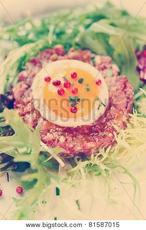 Beef tartare in plate, close-up shot, toned image