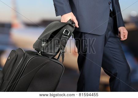 Young Businessman  In  A Modern  Stylish Suit With  Luggage In  The Airport.