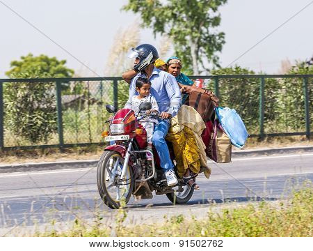Mother, Father And Small Child Riding On Scooter Through Busy Highway
