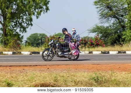Couple Rides On Scooter Through Busy Highway Street