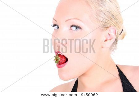 Foto luminosa della giovane bionda con fragola In bocca