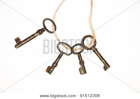 A Lot Vintage Keys On A Rope On White Background