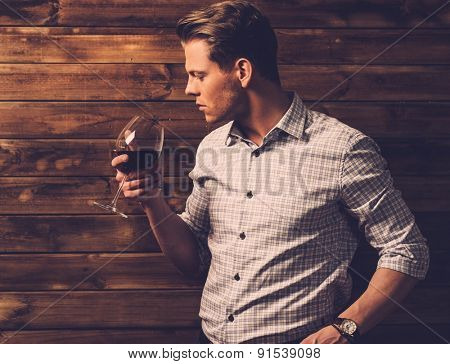 Man tasting wine in rural cottage interior 