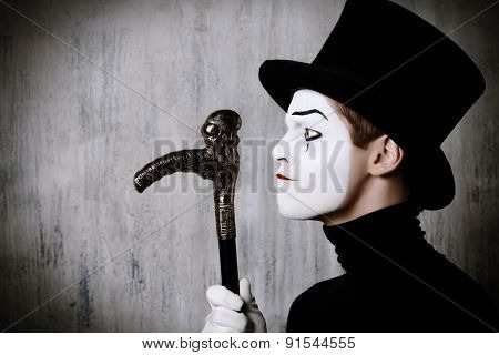 Portrait in profile of a male mime artist performing different emotions. Grunge background.