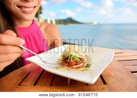 Tuna tartare. Raw ahi, Hawaiian food. Woman eating dish on Waikiki, Oahu, Hawaii.