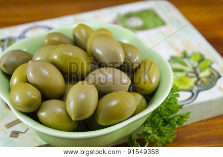 Green Olives And Raw Parsley On A Decoupage Decorated Board
