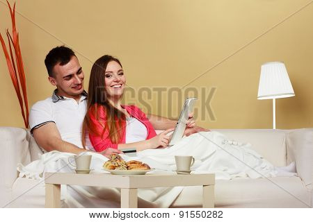 Young Couple With Tablet And Credit Card At Home