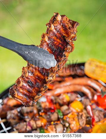 Delicious pork spareribs on grill grate, garden barbecue.