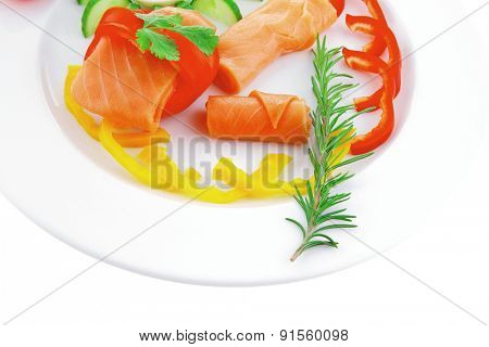 smoked salmon slices with vegetabls over white plate