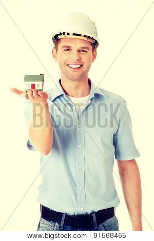 A forewoman holding a model house in hand