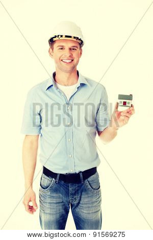 A forewoman holding a model house in hand
