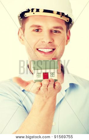 A forewoman holding a model house in hand