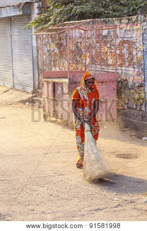 Woman Of Fourt Class In Brightly Colored Clothing Cleans The Street