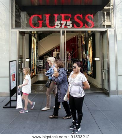NEW YORK CITY - FRIDAY, MAY 8, 2015:  Pedestrians walk past a Guess Clothing retail store in Manhattan. Guess is an American upscale clothing brand and retailer.   