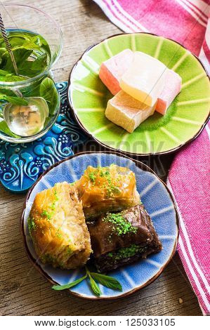 Traditional turkish dessert - mint tea and bakhlava on rustic background