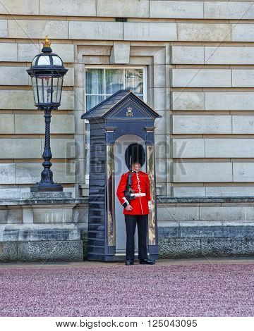 LONDON ENGLAND - APRIL 30 2011: Queen Guard at his post at Buckingham Palace in London in England. Queen Life Guard is a cavalry and infantry soldier who guards royal residences in the UK.