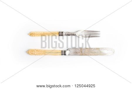 Set of vintage dinnerware. Knife and fork with bone handles on a white background. Top view