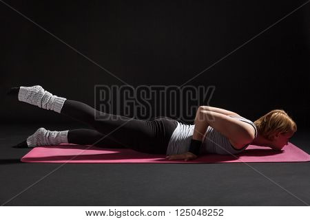 Young woman practicing yoga, Salabhasana / Locust pose